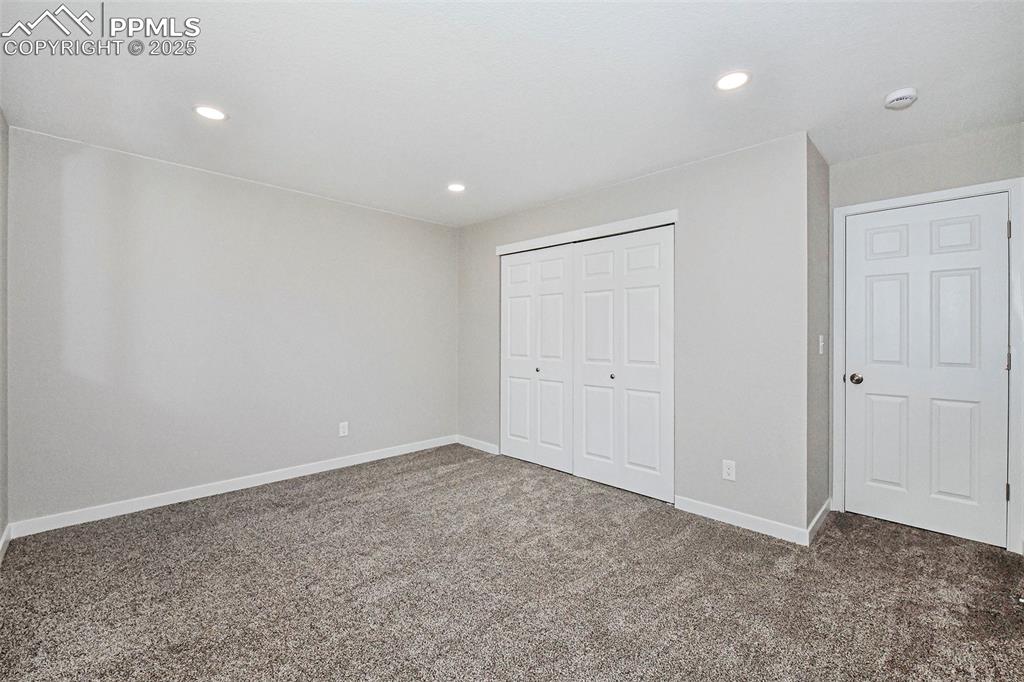 Image 16 of 25: Unfurnished bedroom with carpet, a closet, and recessed lighting