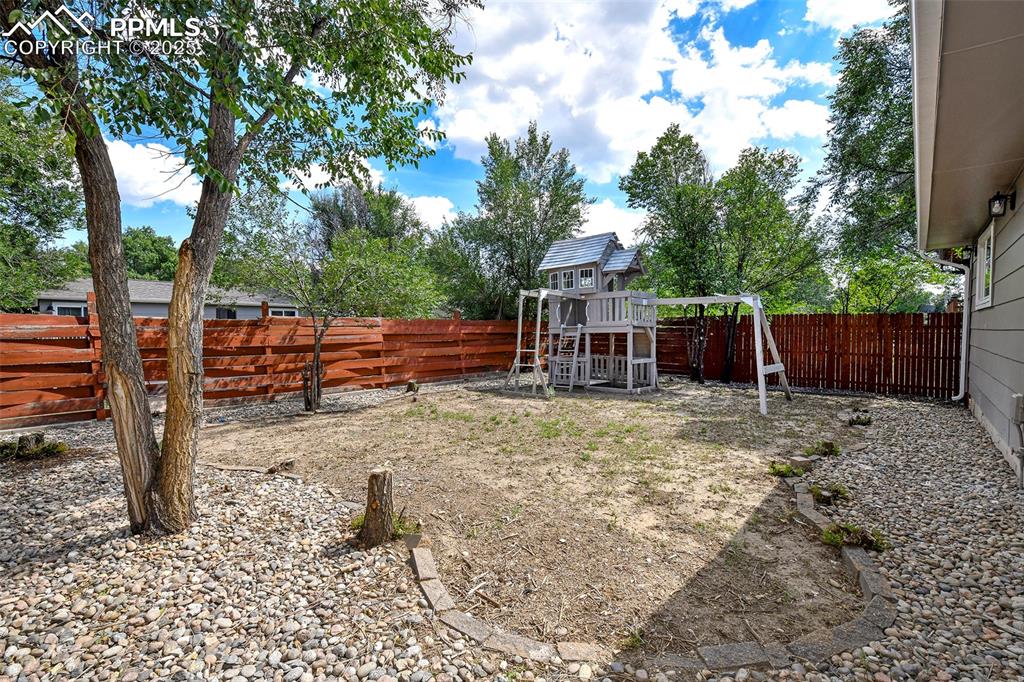 Image 25 of 25: Fenced backyard featuring a playground