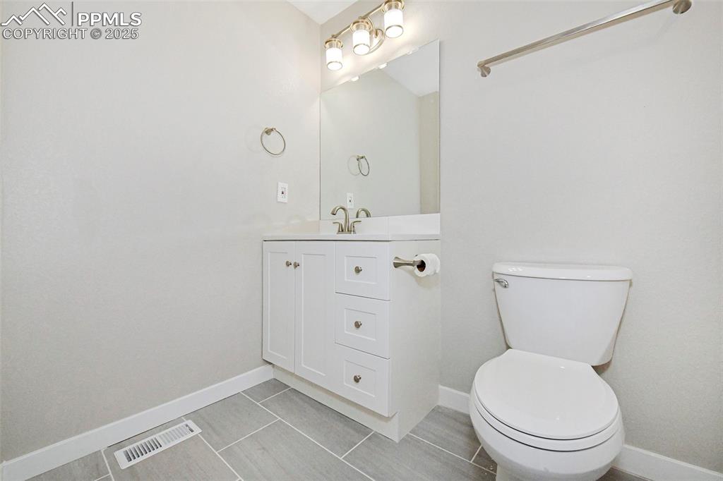 Image 6 of 25: Half bathroom with vanity and light tile patterned floors