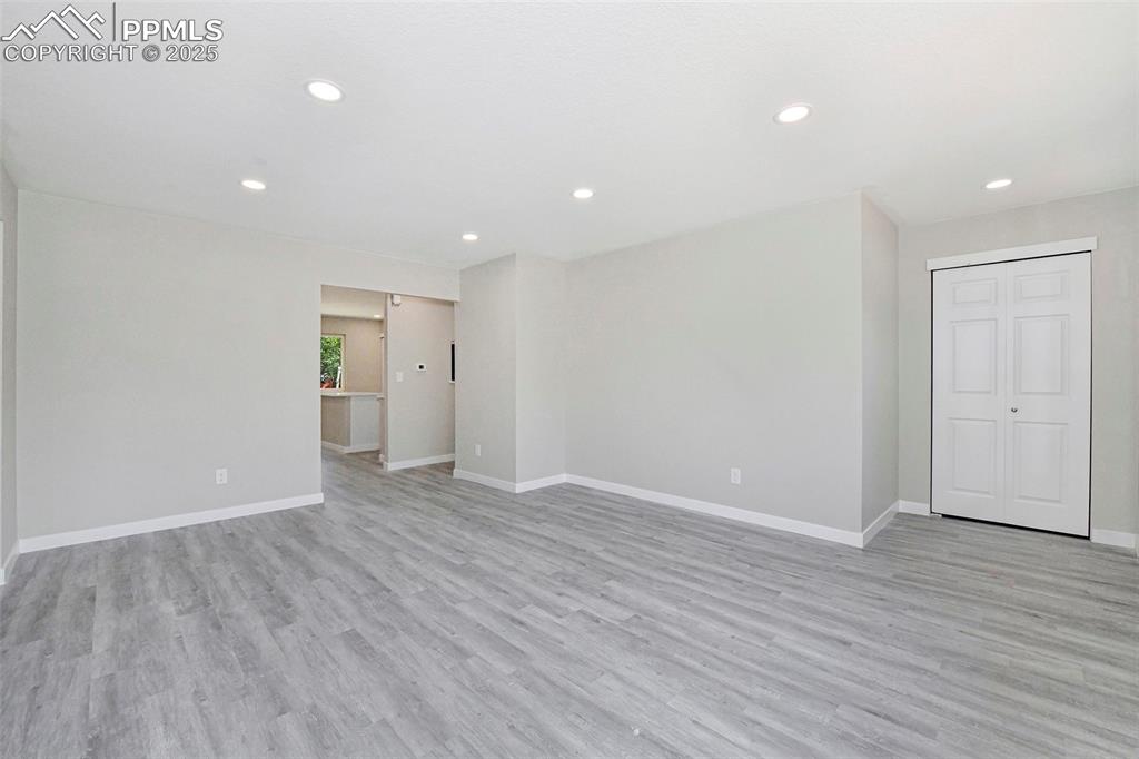 Image 9 of 25: Empty room with light wood-type flooring and recessed lighting