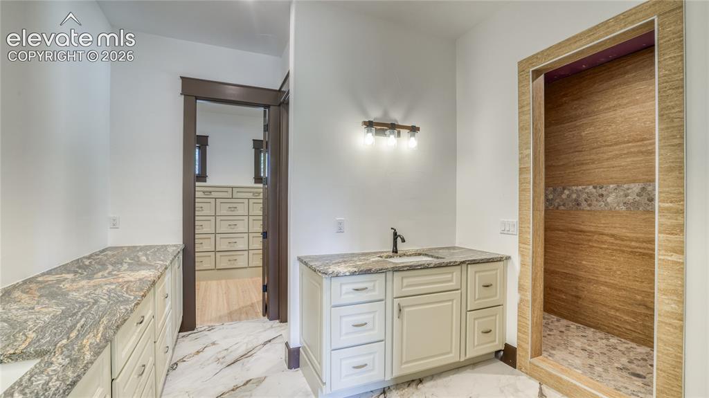 Image 24 of 37: MAIN LEVEL ENSUITE BATHROOM AND WALK-IN CLOSET