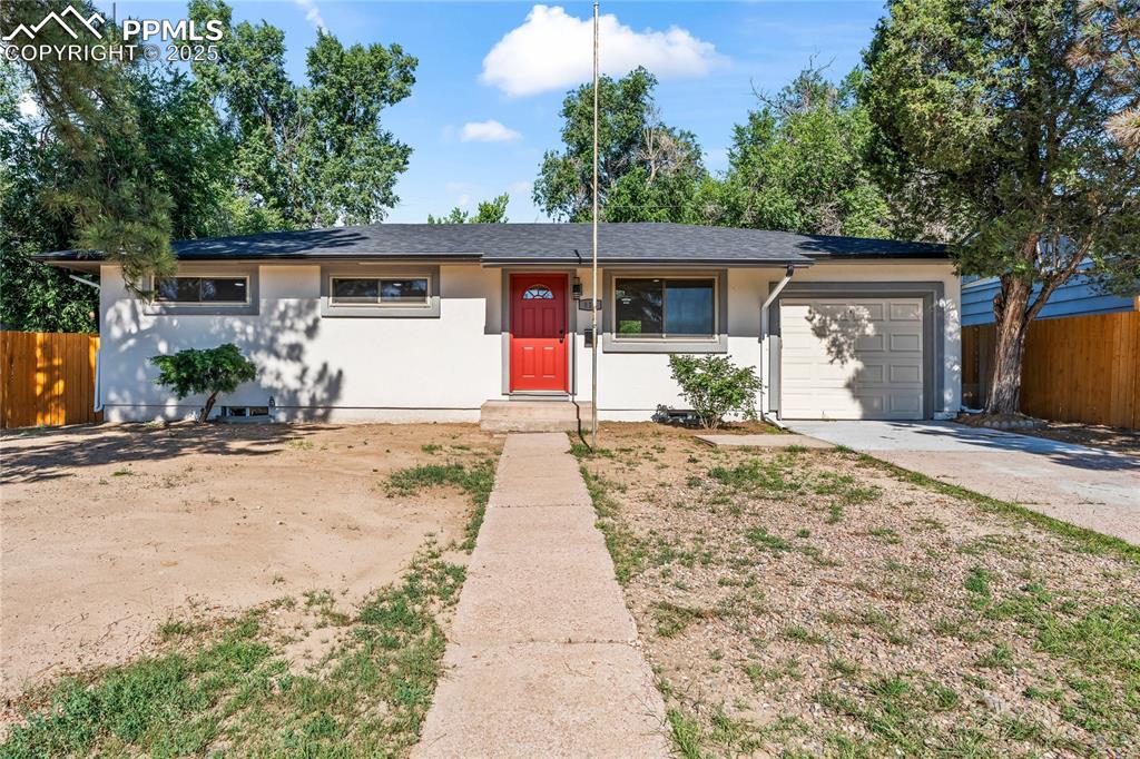 Caption: Single story home featuring stucco siding, a garage, and driveway