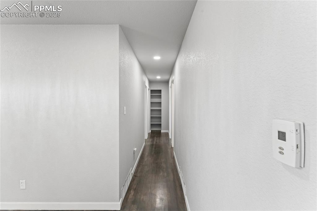 Image 10 of 36: Hallway with dark wood-style flooring and recessed lighting