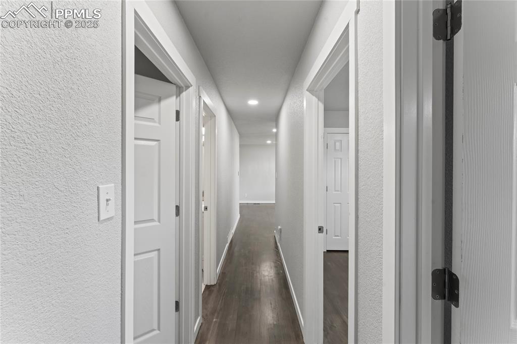 Image 14 of 36: Hall featuring dark wood finished floors and a textured wall