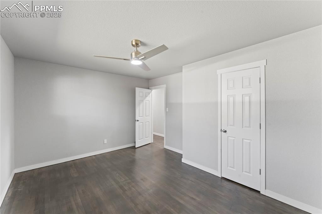Image 18 of 36: Unfurnished bedroom featuring dark wood-style floors and ceiling fan