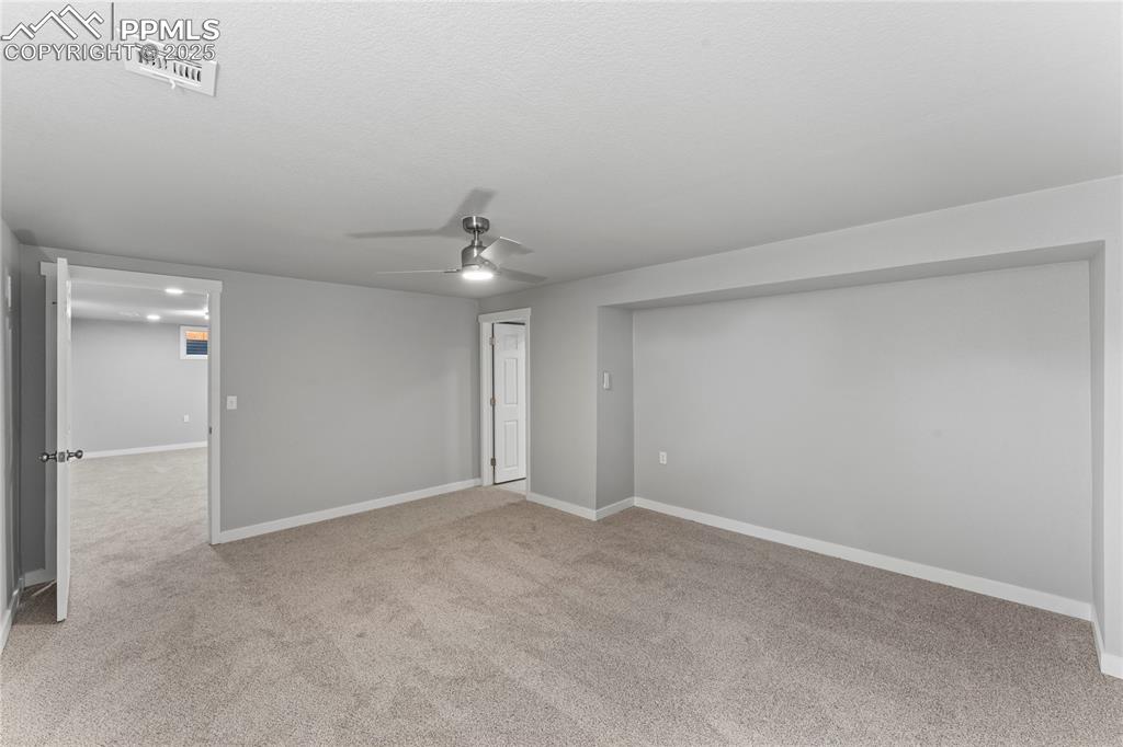 Image 26 of 36: Carpeted empty room with a ceiling fan and a textured ceiling