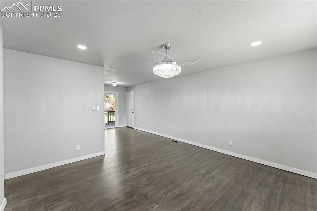 Image 3 of 36: Spare room with dark wood finished floors and recessed lighting