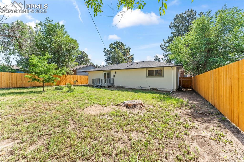 Image 33 of 36: Back of property featuring a fenced backyard and stucco siding