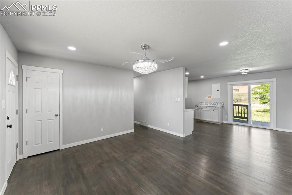Image 4 of 36: Unfurnished living room with dark wood-type flooring and recessed lighting