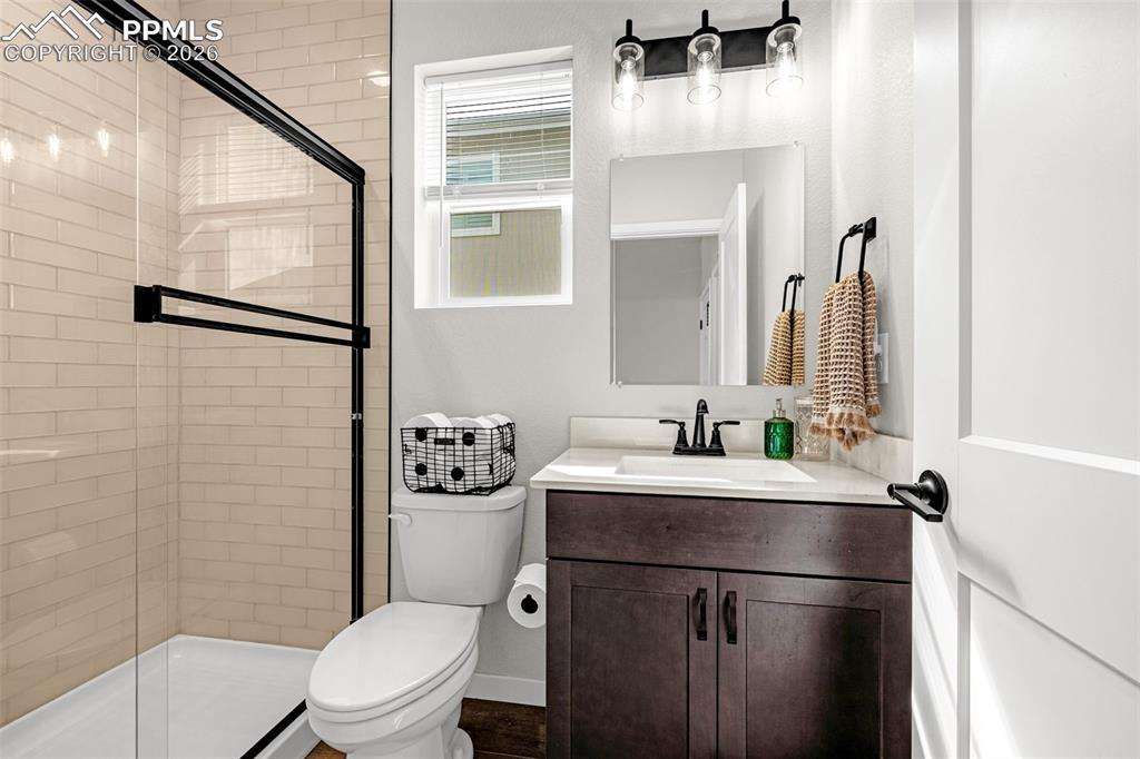 Image 15 of 40: Main level full bathroom with a granite vanity  and a large walk in shower 