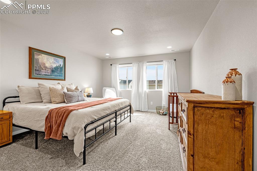Image 20 of 40: Huge primary bedroom on the upper level featuring fresh clean carpet, reces
