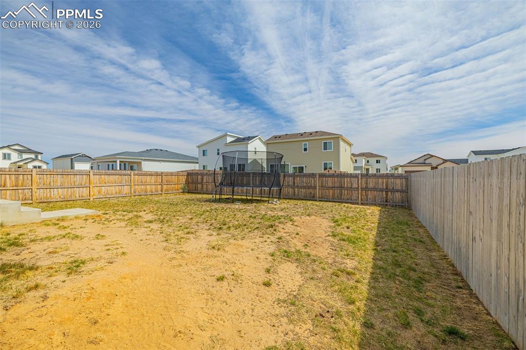 Image 32 of 40: Rear view of house featuring a large fenced in backyard for privacy 