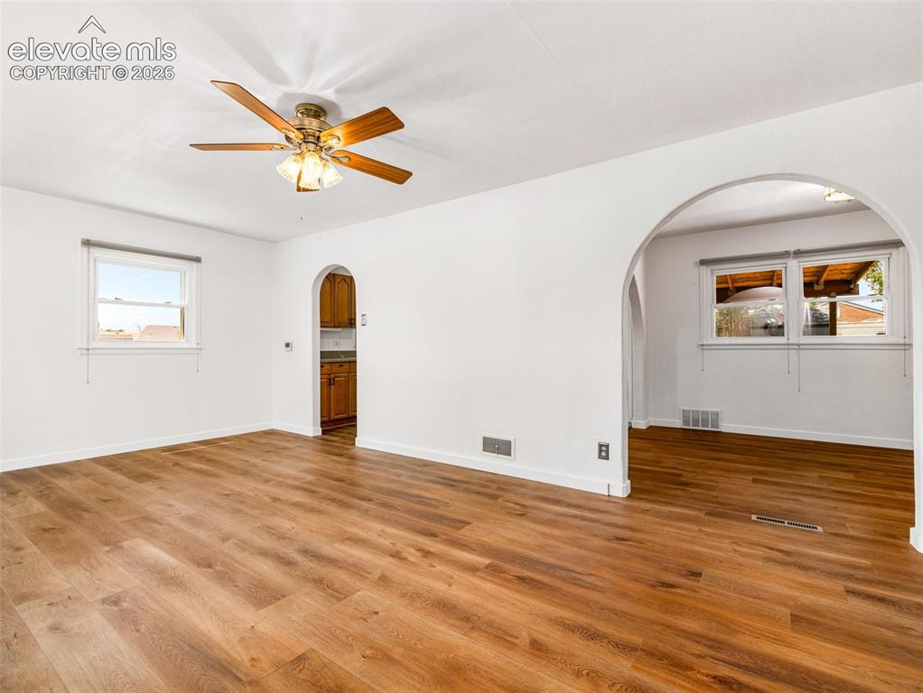 Image 10 of 37: Large archway leads to the dining area and the other to the kitchen