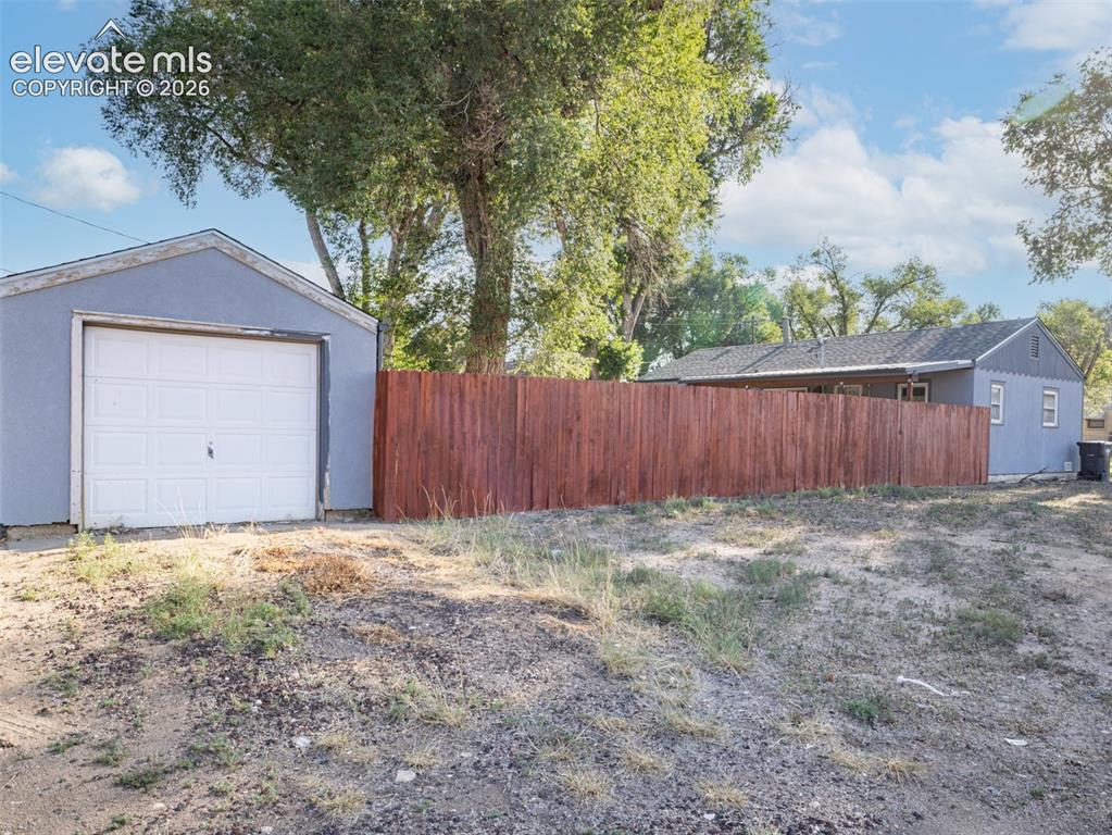 Image 3 of 37: Privacy fence around the home, detached garage