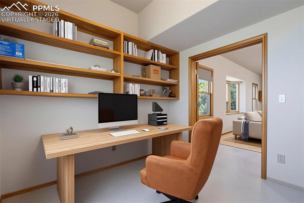 Image 31 of 50: virtually staged Built-in wooden shelving and desk unit provides functional