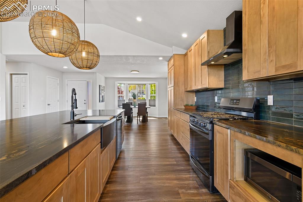 Image 10 of 48: black stainless appliances and impressive hood