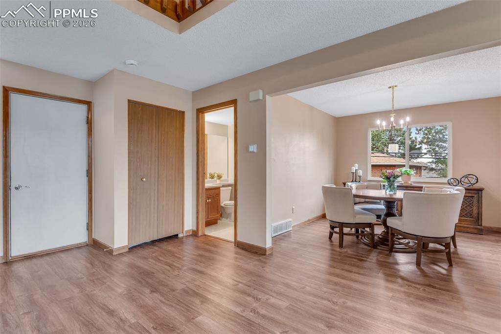 Image 13 of 34: Garage door, hall closet, 1/2 bath with laundry attached, dining room
