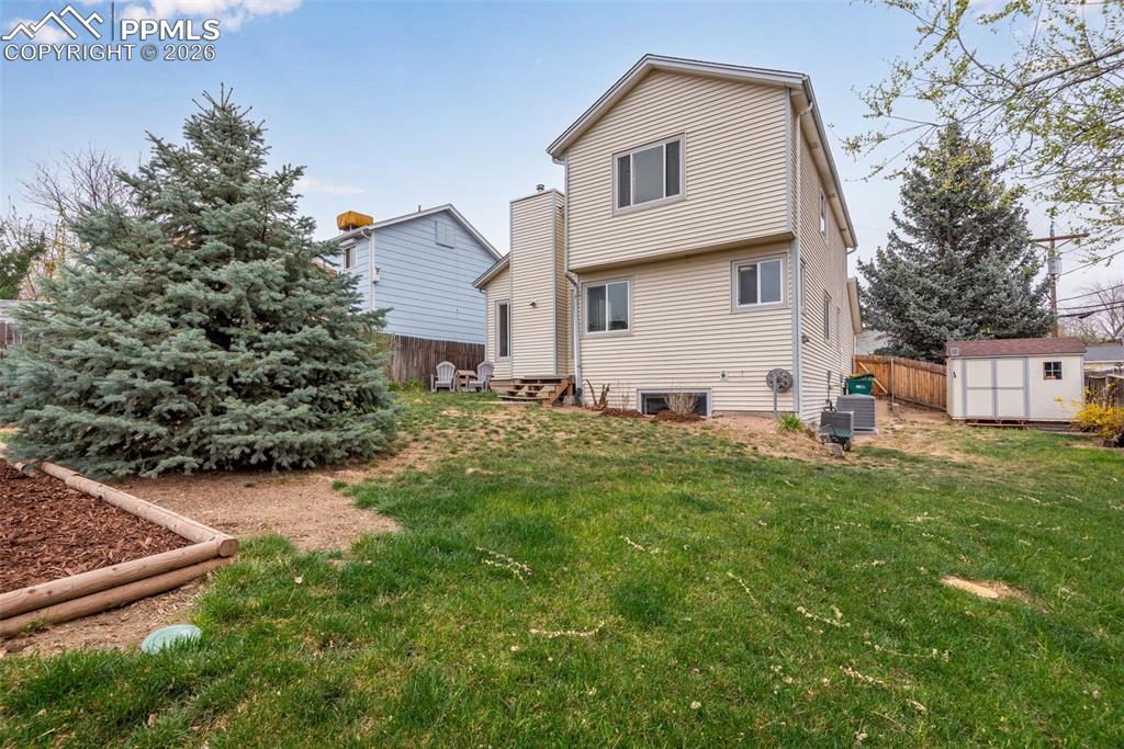 Image 5 of 34: Backyard area with storage shed on the side of the yard