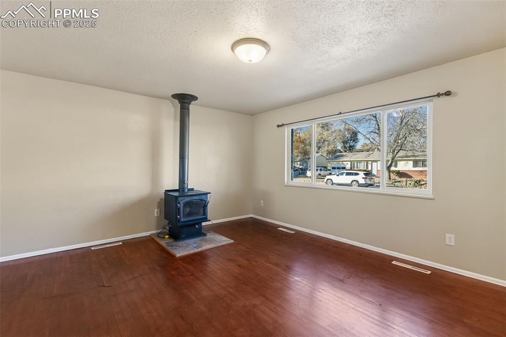 Image 8 of 25: Cozy living area features wood-burning stove