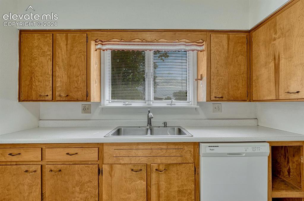 Image 14 of 50: Kitchen featuring wood-finish cabinetry, a double basin stainless steel sin