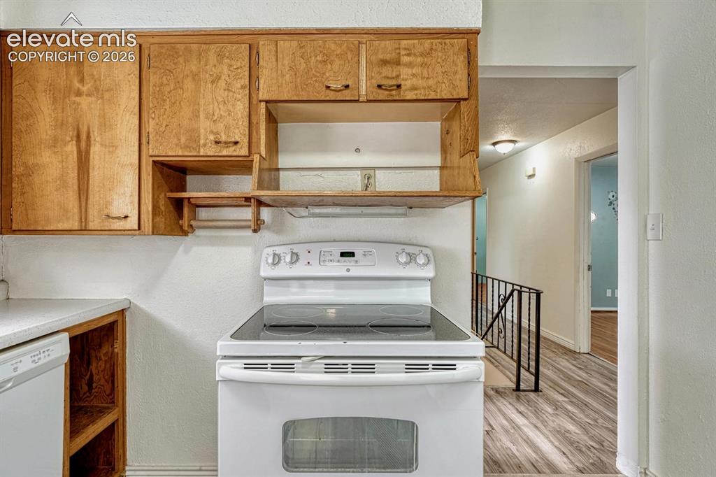 Image 15 of 50: Kitchen featuring a white electric range with a glass cooktop, solid wood u
