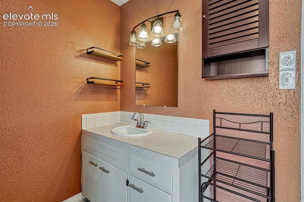 Image 19 of 50: Vanity with an integrated sink, polished chrome faucet, and white counterto