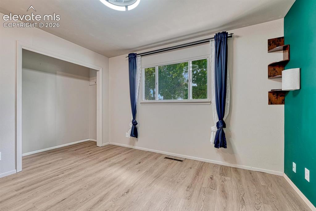 Image 23 of 50: Bright room featuring laninate flooring, a double window, recessed closet, 