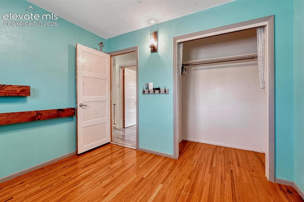 Image 30 of 50: Room featuring wood-finish flooring, a built-in closet with a hanging rod, 