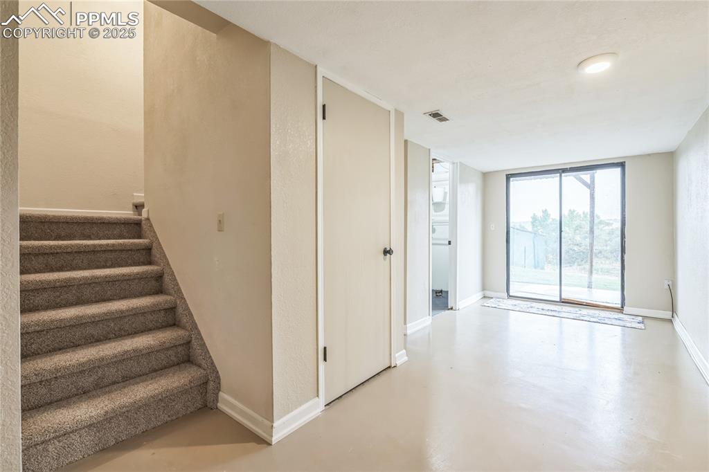 Image 11 of 21: Staircase with finished concrete floors and baseboards