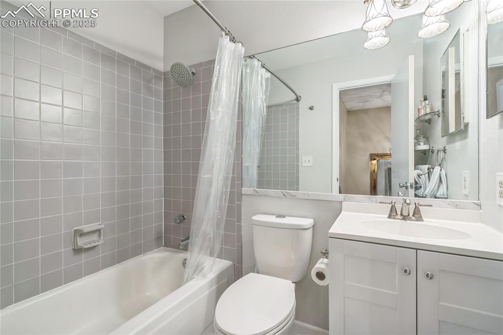 Image 12 of 21: Full bathroom with shower / bath combo with shower curtain and vanity
