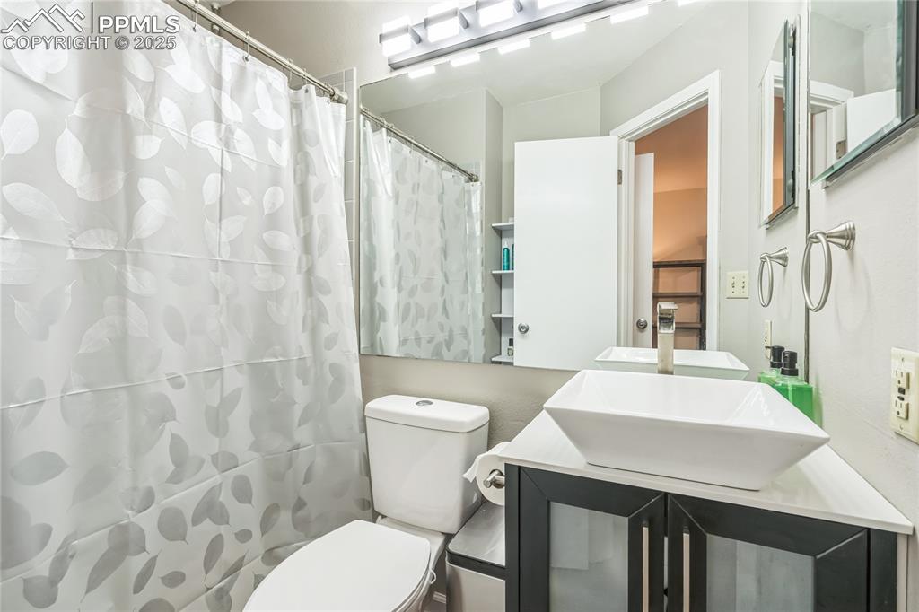 Image 13 of 21: Full bathroom with vanity and a shower with shower curtain