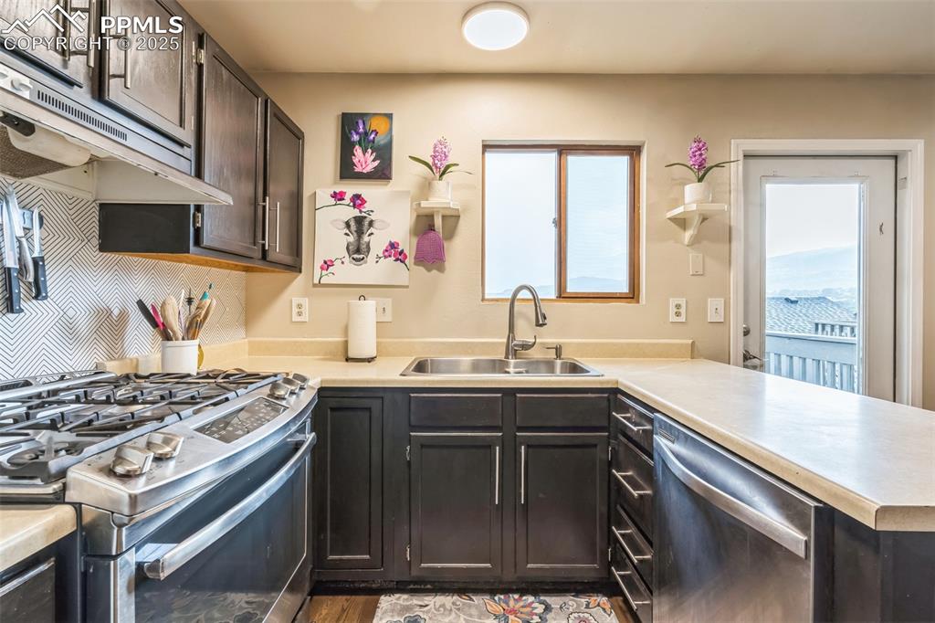 Image 5 of 21: Kitchen with stainless steel appliances, a peninsula, light countertops, un