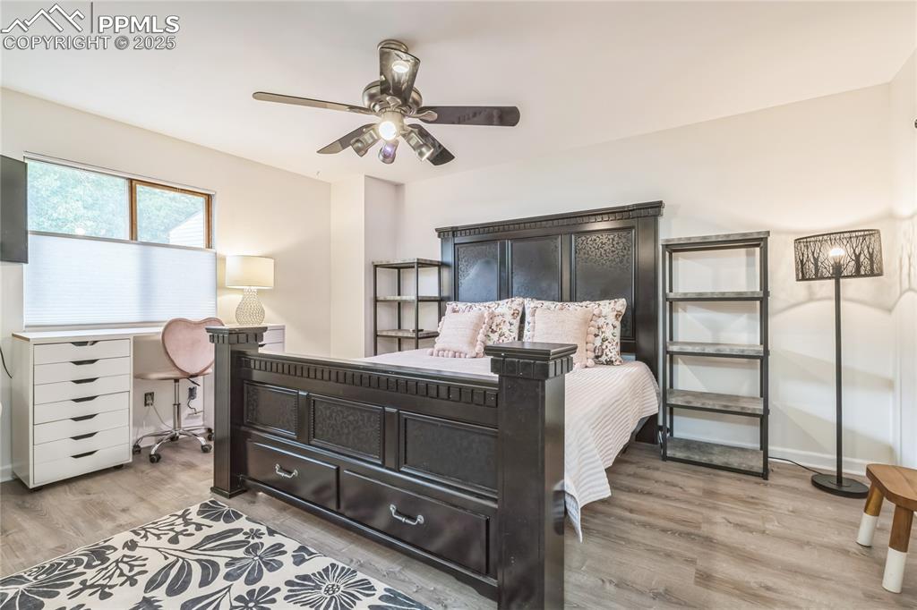 Image 7 of 21: Bedroom with an office area, light wood-type flooring, and a ceiling fan