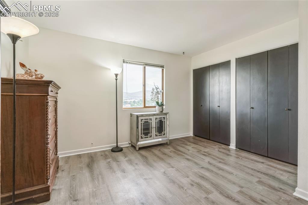 Image 9 of 21: Unfurnished bedroom with multiple closets and wood finished floors