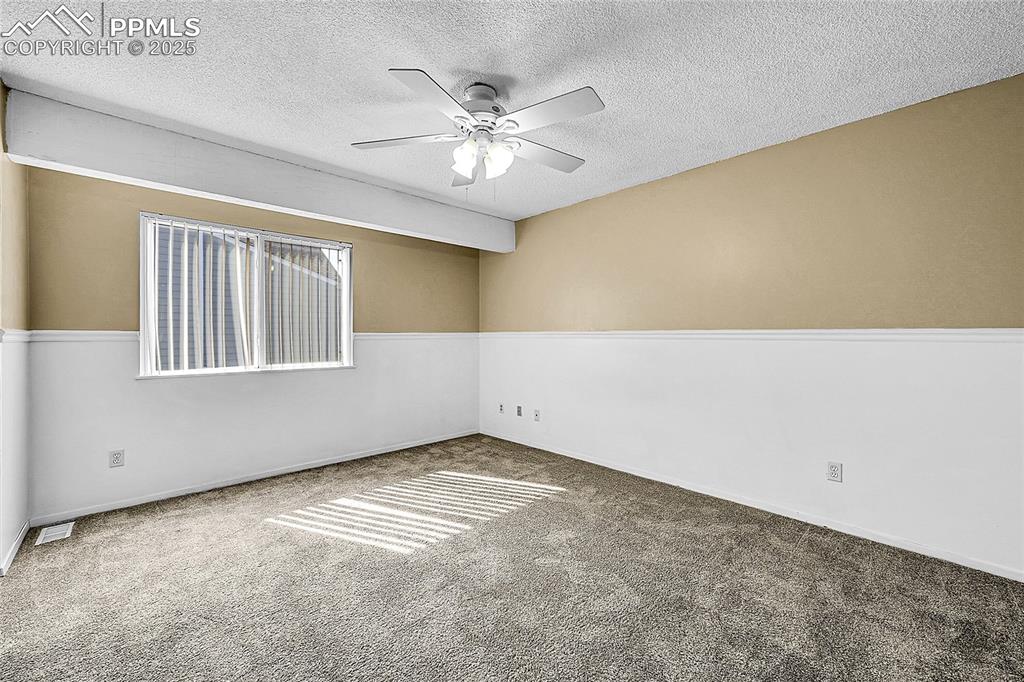 Image 9 of 12: Unfurnished room with carpet flooring, a textured ceiling, and a ceiling fa