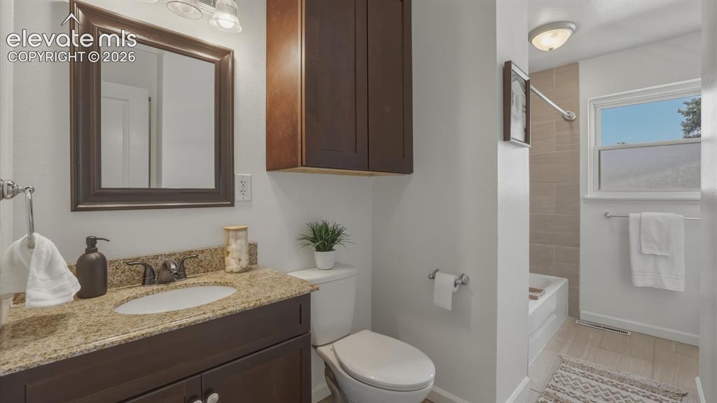 Image 13 of 48: The Upper Level Full Bathroom features a granite vanity, framed mirror, sto