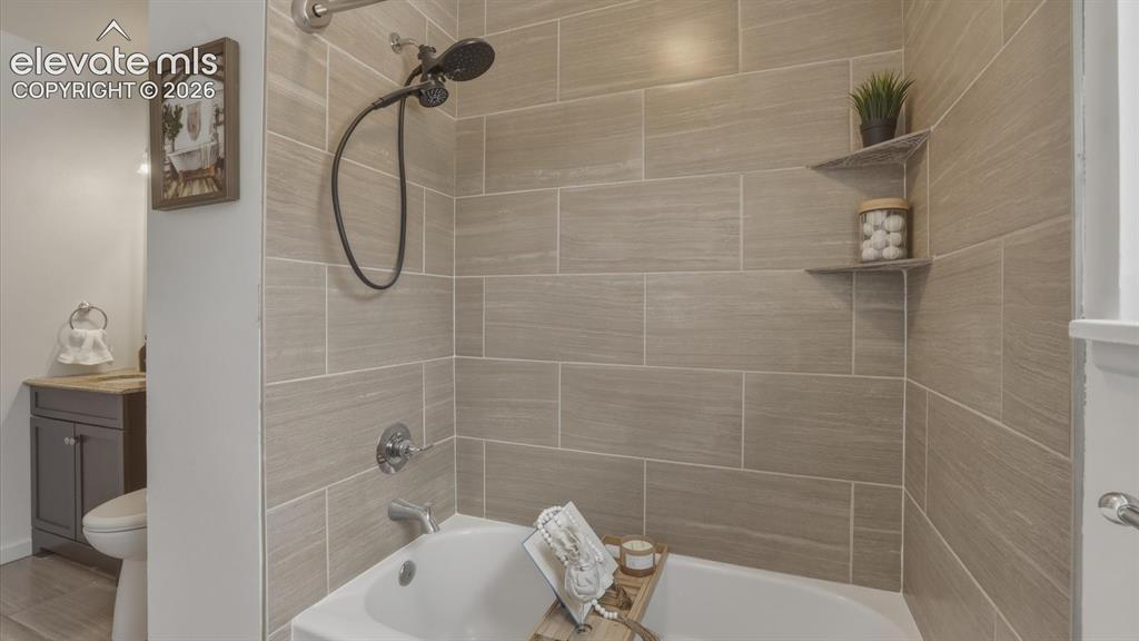 Image 14 of 48: Tiled tub/shower in upper level Full Bathroom.