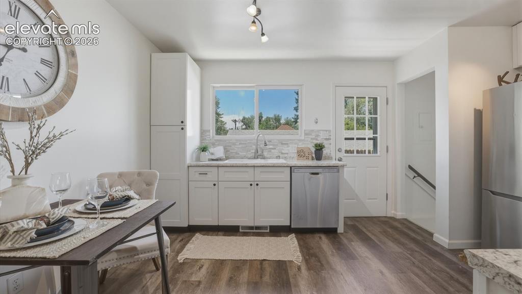 Image 23 of 48: The Kitchen has a door to the backyard and stairs to the Lower Level.