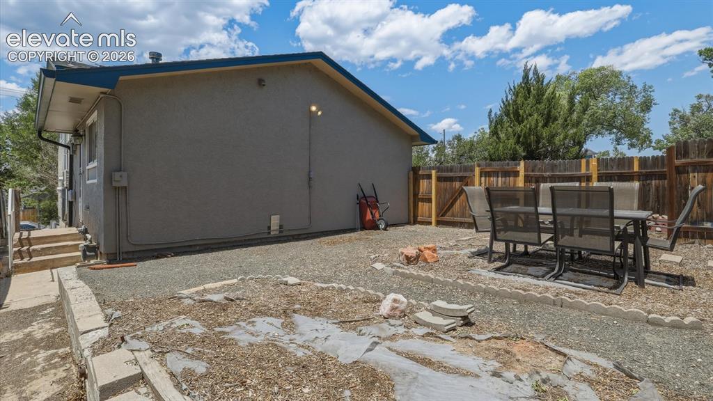 Image 34 of 48: The fenced backyard offers plenty of space to relax, garden, or entertain.