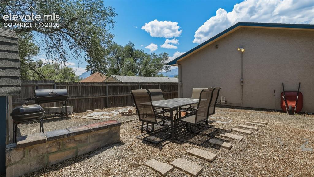 Image 35 of 48: Fenced level backyard with areas for outdoor dining and entertaining.