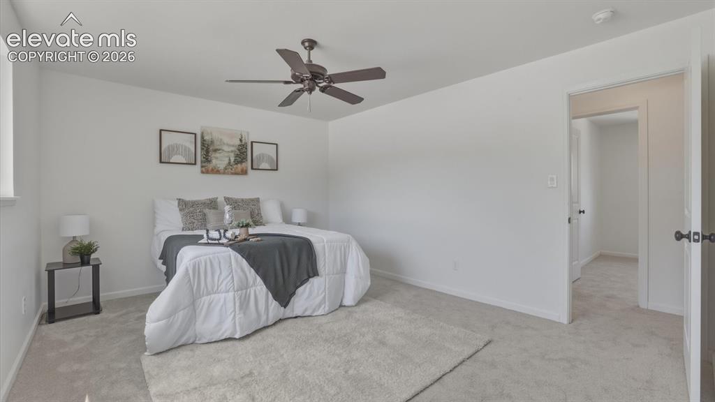 Image 9 of 48: The spacious primary bedroom includes a ceiling fan and private bath acces