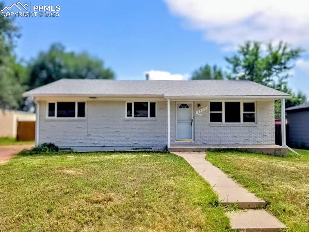 Caption: Ranch-style home featuring brick siding and a front lawn