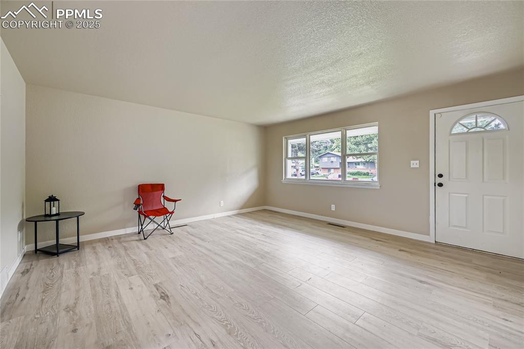 Image 11 of 25: Foyer entrance featuring light wood-type flooring and a textured ceiling