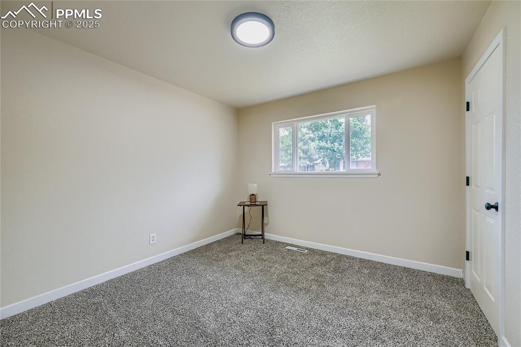 Image 12 of 25: Empty room featuring baseboards and carpet