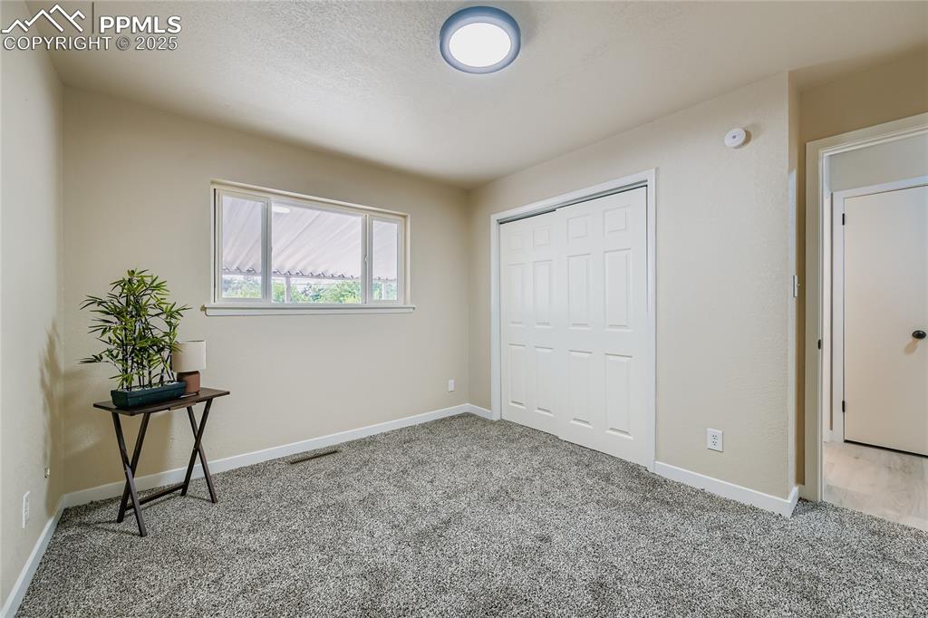 Image 13 of 25: Unfurnished bedroom with carpet floors, a closet, and a textured ceiling