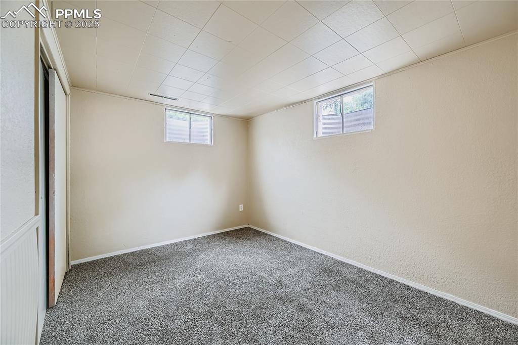 Image 18 of 25: Basement featuring plenty of natural light and carpet flooring