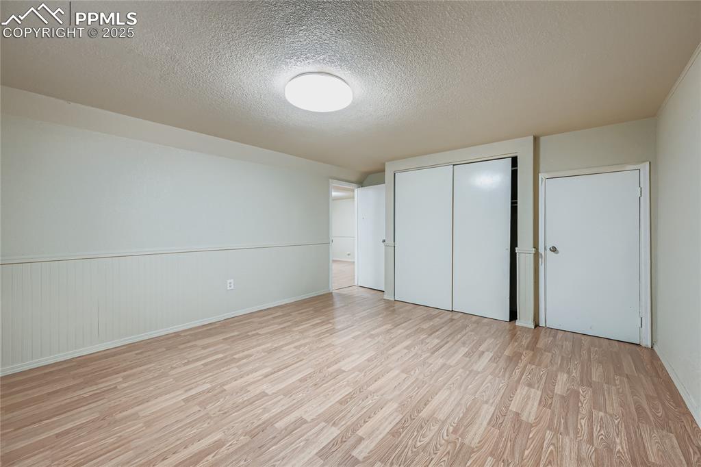 Image 20 of 25: Unfurnished bedroom featuring a textured ceiling, light wood finished floor
