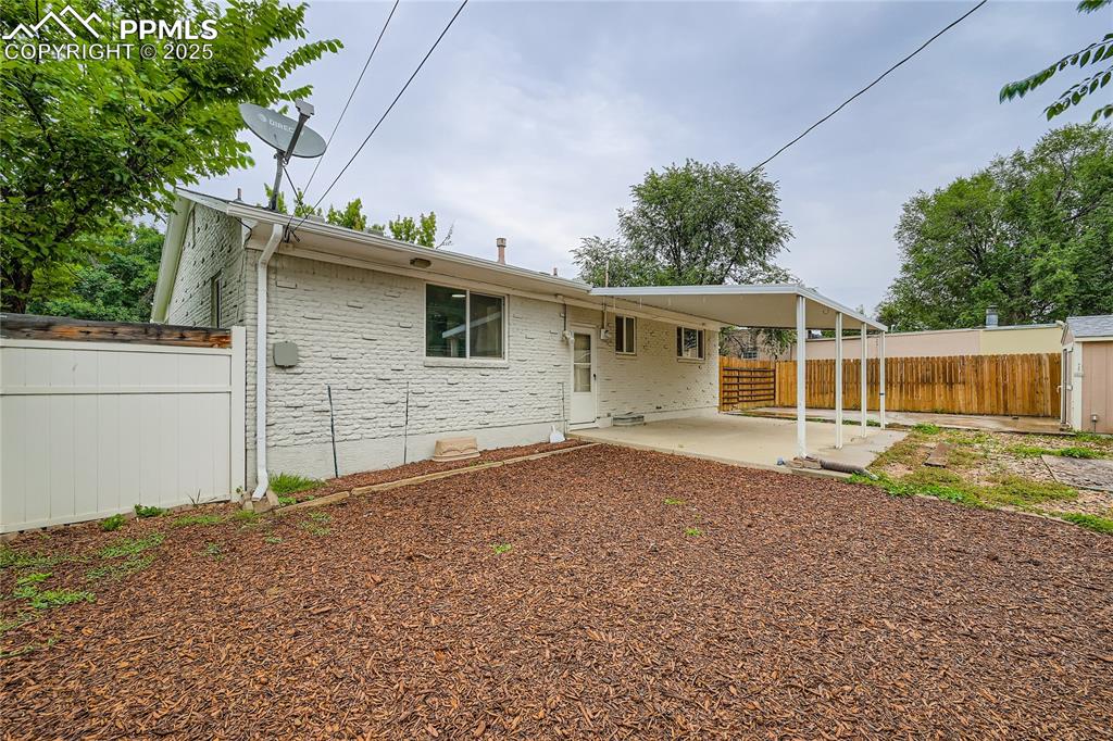 Image 24 of 25: Rear view of property featuring brick siding, a patio, an outdoor structure