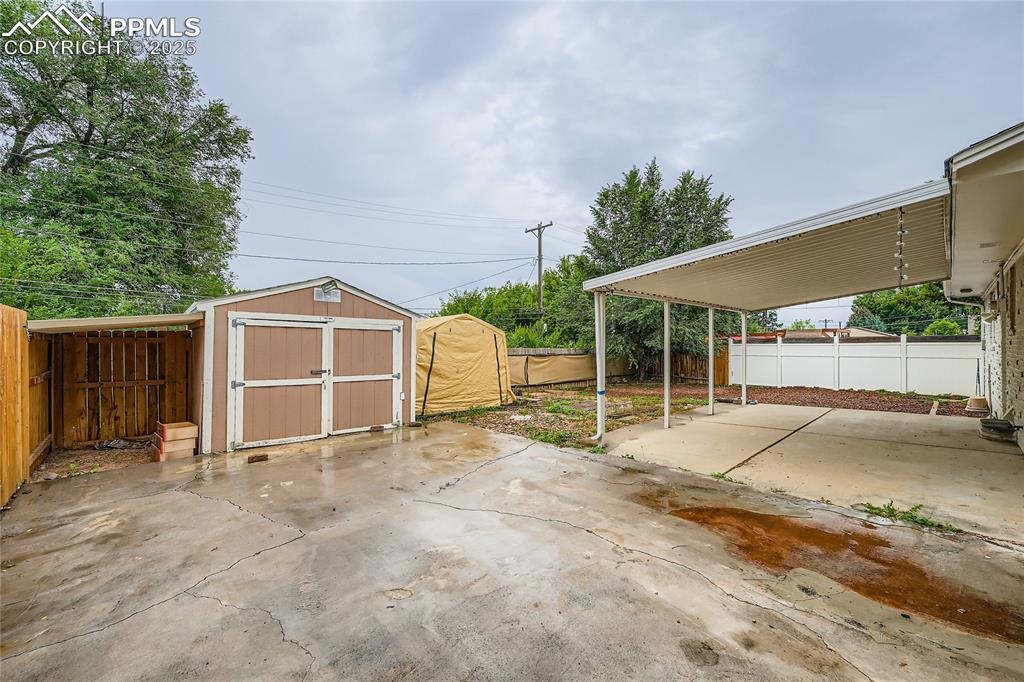 Image 25 of 25: Fenced backyard featuring a storage shed and a patio area