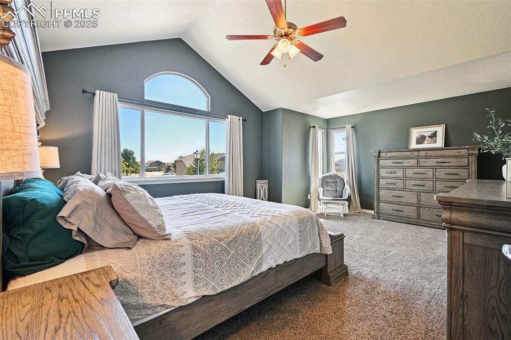 Image 10 of 39: Bedroom featuring carpet, vaulted ceiling, and ceiling fan